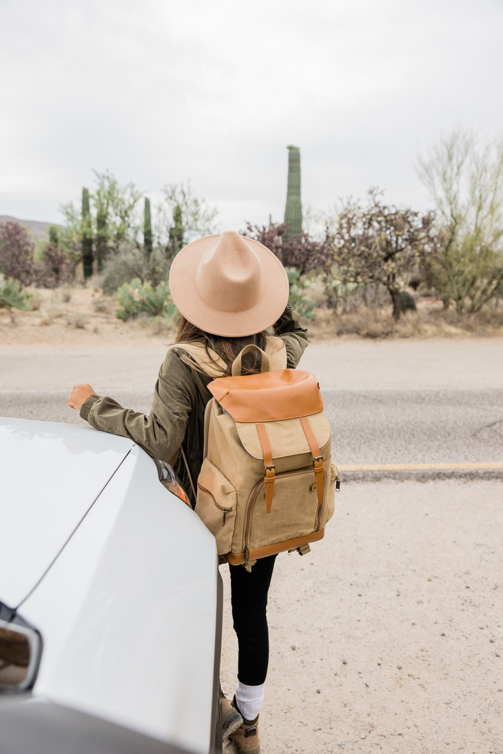 Woman in Hat and Backpack Near the Car Outdoors